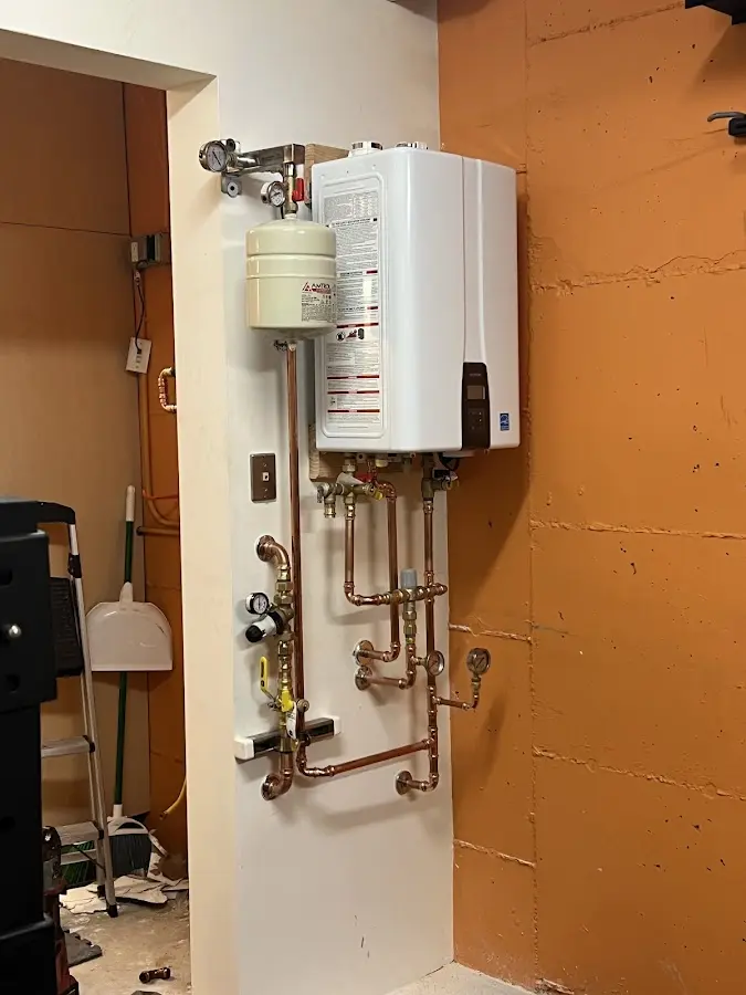 Plumbing technician inspecting water heater connections in Hannibal